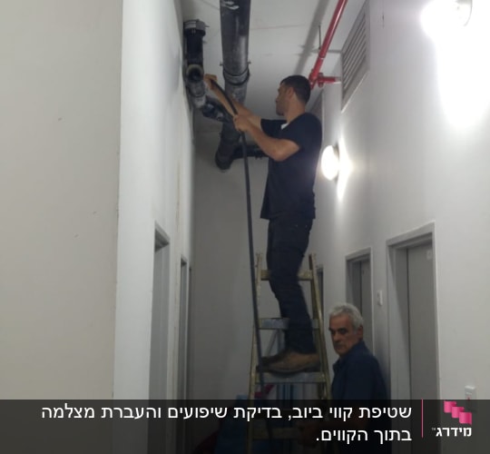 אדם על סולם עובד על צינור תקרה